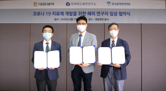 19일 대웅제약 본사에서 열린 코로나19 치료제 개발을 위한 해외연구자 임상 협약식에서 김동호 한국원자력의학원 임상연구부장(맨 왼쪽부터), 전승호 대웅제약 대표, 류왕식 한국파스퇴르연구소 연구소장이 협약서에 서명한 후 기념촬영을 하고 있다.    대웅제약 제공